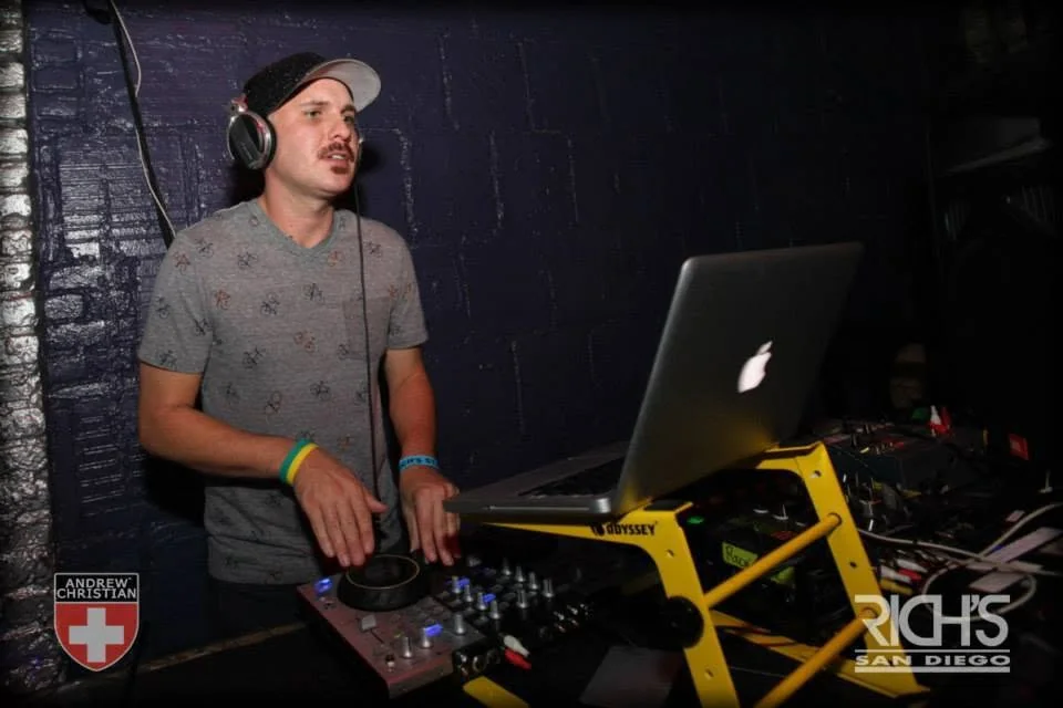 DJ Will Z performing at a nightclub booth