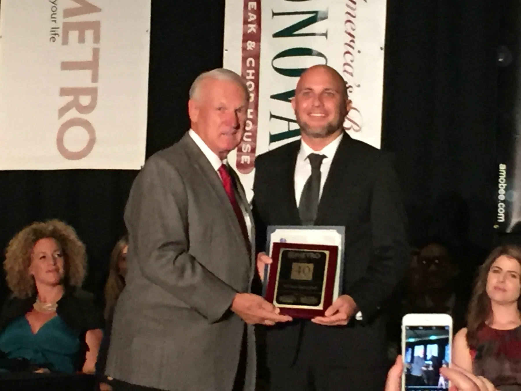 William Zakrajshek receiving a plaque on stage