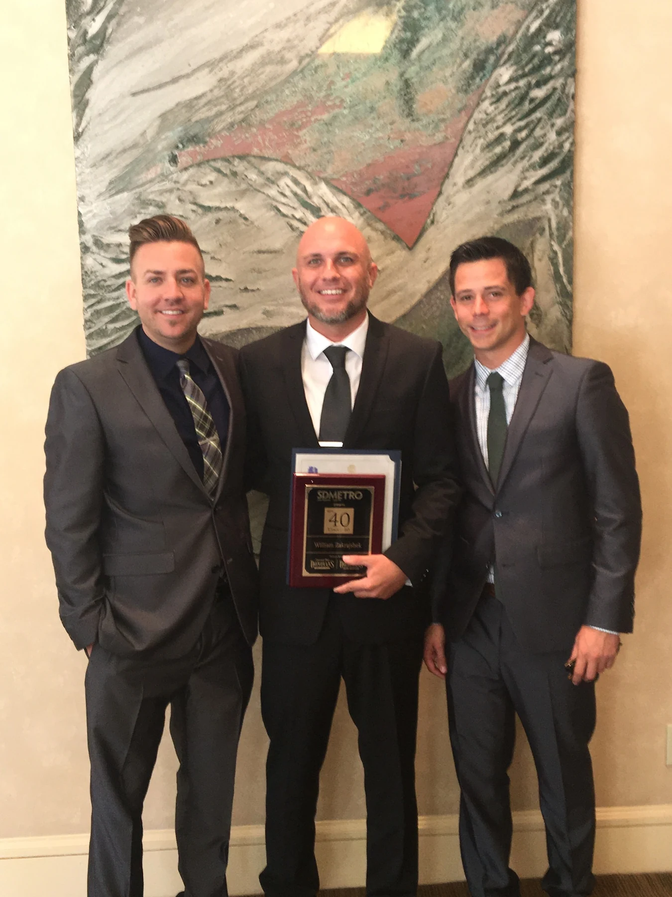 William Zakrajshek receiving an award with two presenters